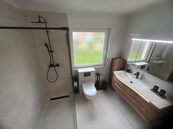 Von SHK Cakal saniertes Badezimmer mit bodengleicher Glasdusche und modernem Waschtisch